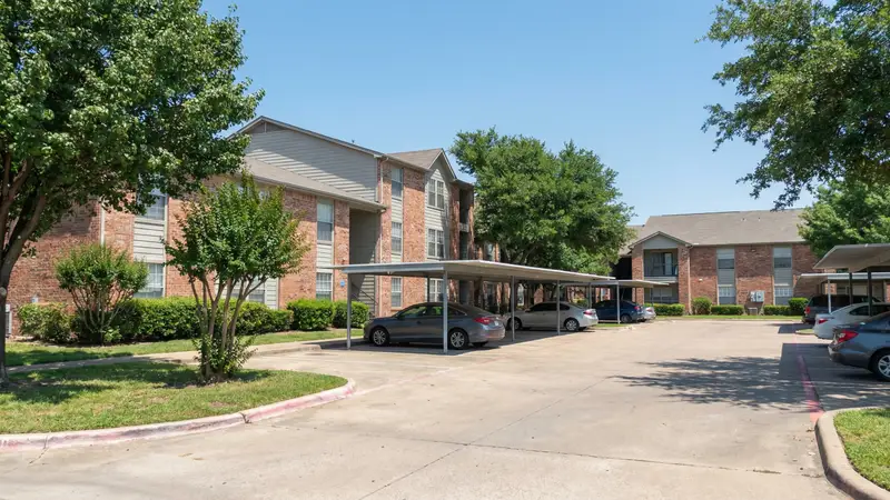 Affordable apartment complex in Mesquite Texas suburb with covered parking and green landscaping