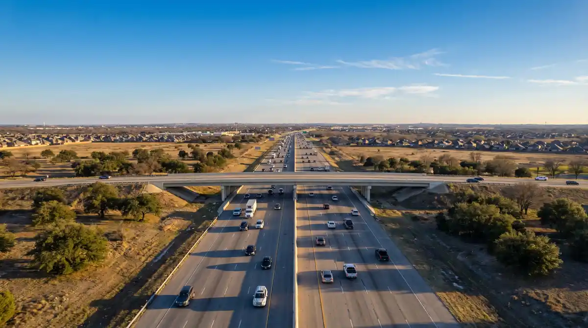 Aerial view of Texas highway and overpass — transportation cost comparison between Houston and Dallas