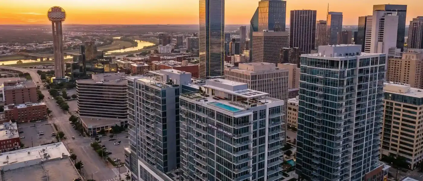 Apartment Locators Dallas — Uptown skyline at dusk with high-rise apartment buildings