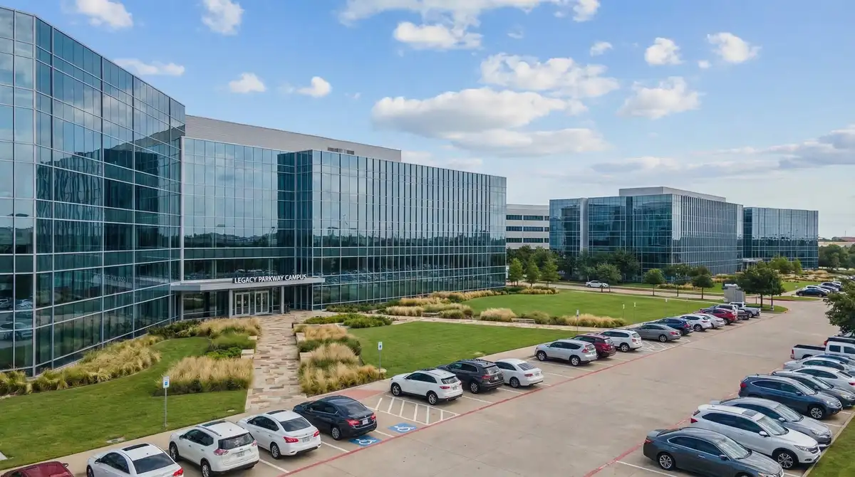 Modern corporate campus in Plano Texas with glass office buildings and manicured landscaping along Legacy Drive
