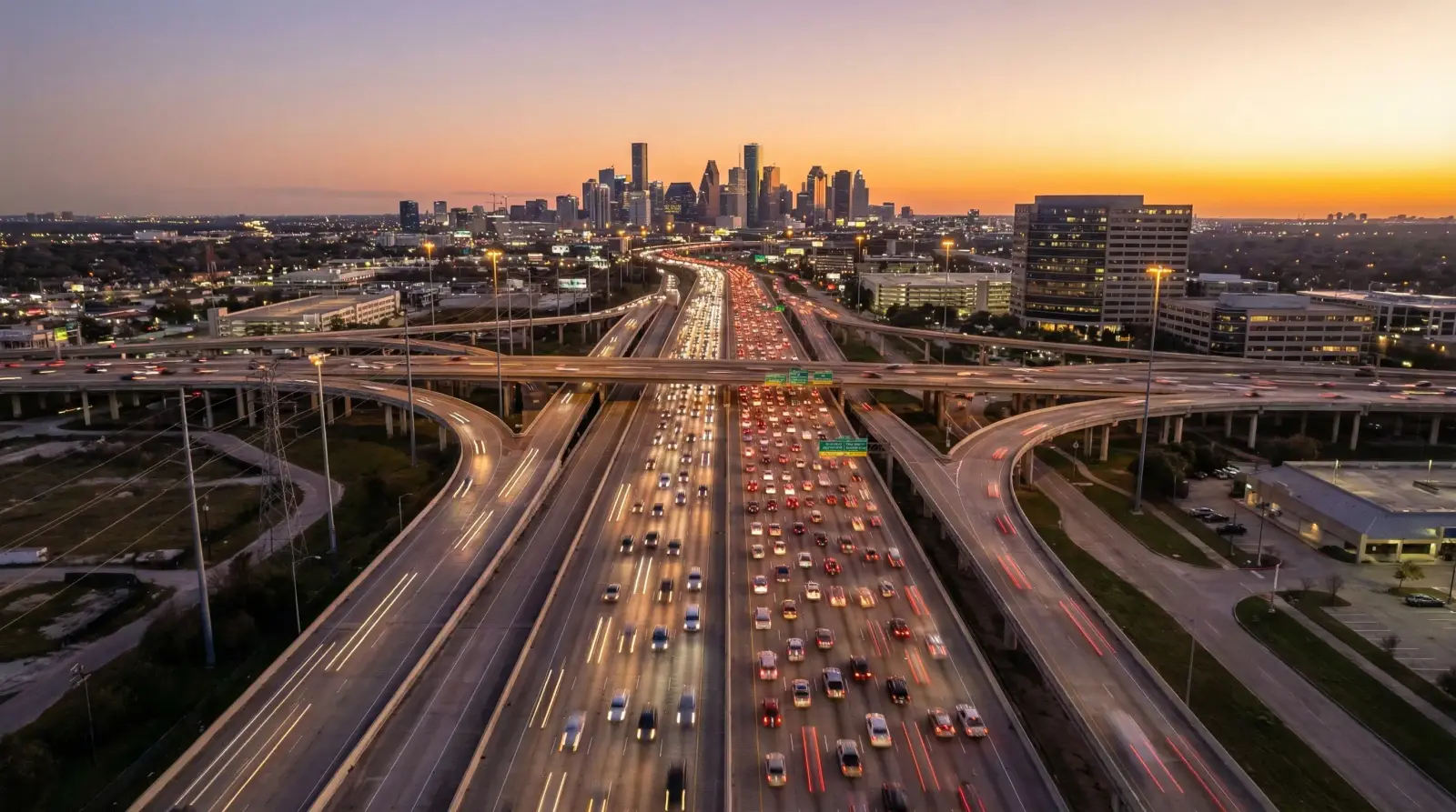 Houston I-10 Katy Freeway aerial view at sunset showing multi-lane highway leading toward downtown Houston Texas skyline