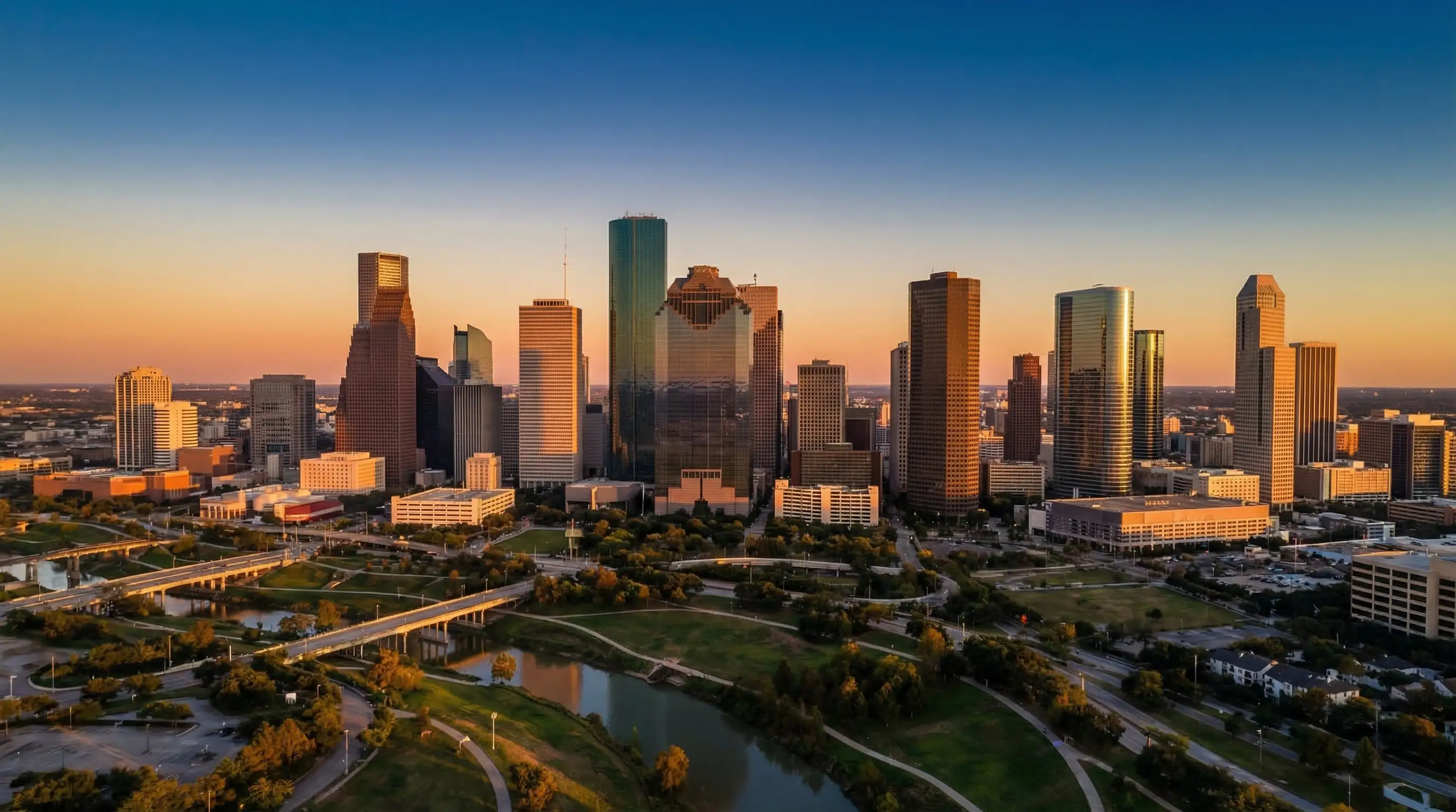 Aerial view of Houston Texas downtown skyline at golden hour with Buffalo Bayou winding through the foreground