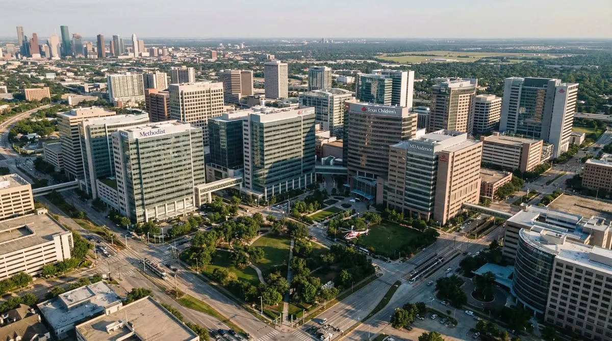 Aerial view of Texas at golden hour with illuminated medical centers in Houston, Dallas, San Antonio, and Austin highlighted on a stylized map